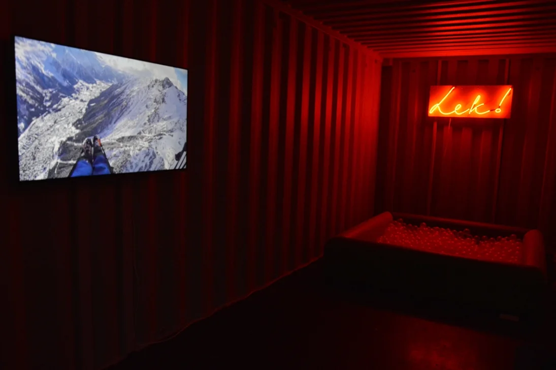 Kristin Bjorseth viser installasjonen LEK fra 2018 som viser en video av hvite vinterfjell og ordet "lek" i oransje neonbokstaver og et kar med såpebobler.