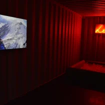 Kristin Bjorseth viser installasjonen LEK fra 2018 som viser en video av hvite vinterfjell og ordet "lek" i oransje neonbokstaver og et kar med såpebobler.